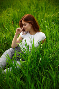 High angle view of young woman lying on grassy field