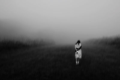 Woman standing on field against sky