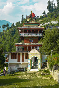 Temple by building against sky