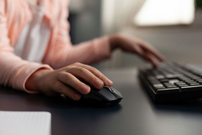 Midsection of person using mobile phone on table