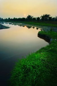 Scenic view of lake against sky at sunset