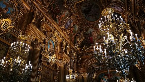 Low angle view of illuminated lighting equipment in temple