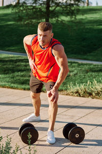 Portrait of boy playing with dumbbell in gym