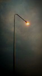 Low angle view of illuminated street light against sky