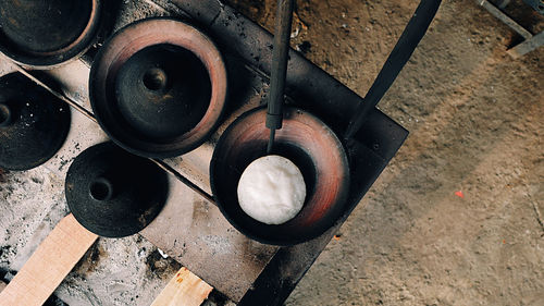 High angle view of surabi, indonesian pancake, cooked upon small earthenware frying pan.