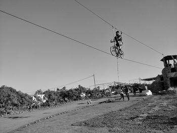 Low angle view of people walking on street against sky