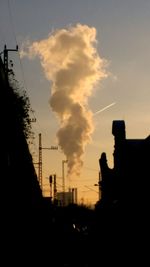Smoke emitting from chimney against sky