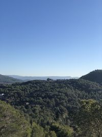 Scenic view of landscape and mountains against clear blue sky