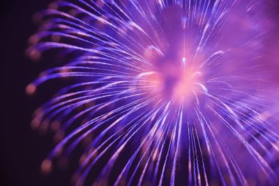 Low angle view of fireworks exploding at night