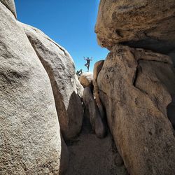 Low angle view of man on cliff against sky