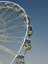 Low angle view of ferris wheel against clear blue sky