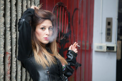 Portrait of woman smoking in city