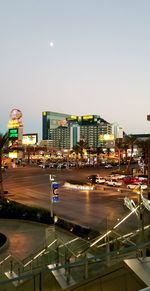 Illuminated city buildings against clear sky at night