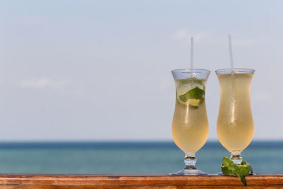 Close-up of drink at beach against sky