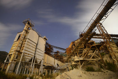 Low angle view of abandoned construction site against sky