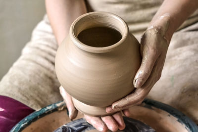 Potter holds more crude to firing of white clay jug. sculptor sculpts pots products from white clay