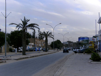 Cars on road in city against sky