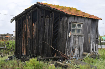 Exterior of old house on field against sky