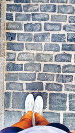 Low section of man standing on cobblestone street