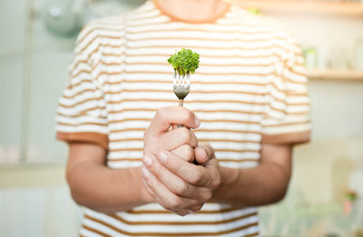 Midsection of woman holding plant