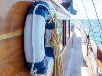 Close-up of life belt and rope hanging on boat