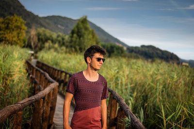 Young man standing on land against sky