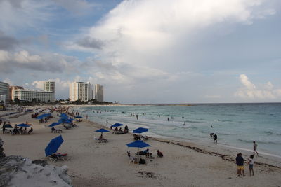 Panoramic view of people on beach against sky