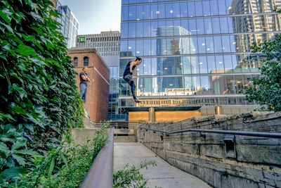 Man standing by staircase against modern buildings in city