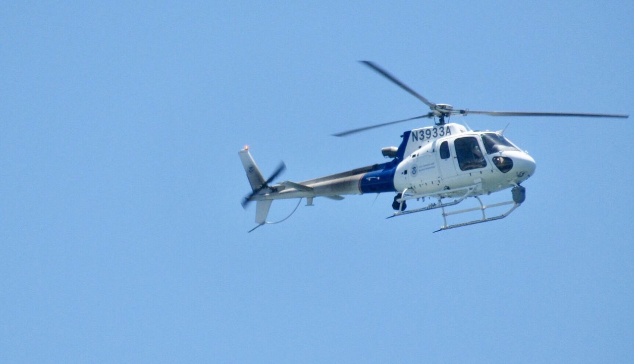 LOW ANGLE VIEW OF AIRPLANE FLYING IN CLEAR BLUE SKY