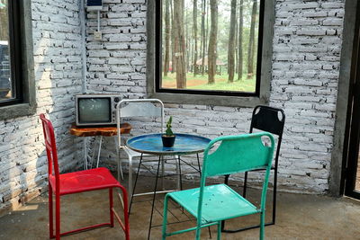 Empty chairs and table against wall in building