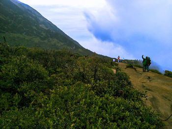 People on mountain against sky