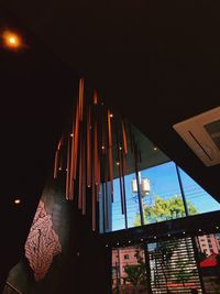 Low angle view of illuminated lights hanging on ceiling of building