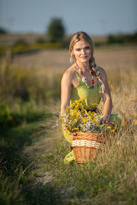 Portrait of young woman standing on field