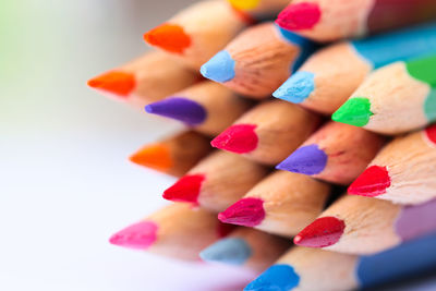 High angle view of multi colored pencils on white background