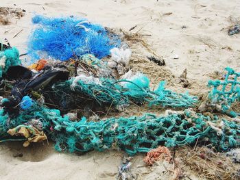 High angle view of messy fishing nets on sand