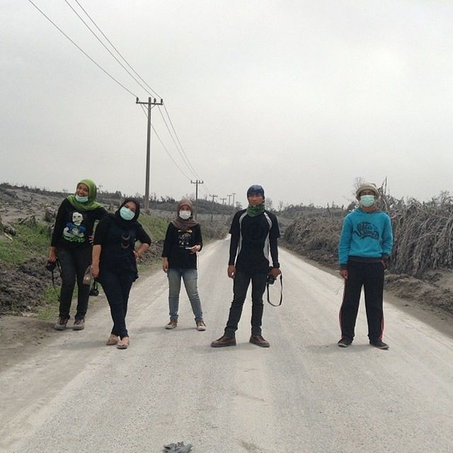 men, walking, lifestyles, rear view, full length, transportation, person, leisure activity, road, street, clear sky, sky, large group of people, casual clothing, power line, day, travel, electricity pylon, togetherness