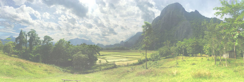 Panoramic view of agricultural field and mountains against sky