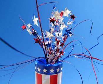 Low angle view of colorful star shape confetti against clear sky