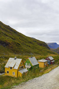 Houses by road amidst buildings against sky