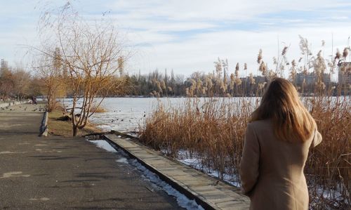 Rear view of woman standing on snow covered landscape