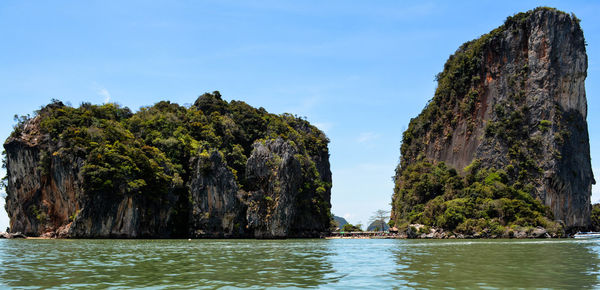 Rock formations by sea against sky