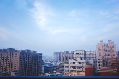 View of cityscape against cloudy sky