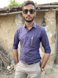 Portrait of young man wearing sunglasses standing outdoors