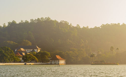 Scenic view of lake by buildings against clear sky