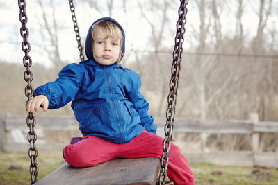 Girl sitting on swing at playground