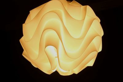 Close-up view of illuminated lamp against black background