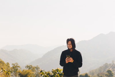 Man standing on mountain against clear sky