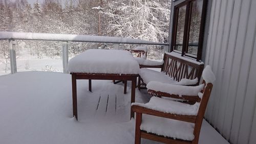 Empty chairs and tables in snow