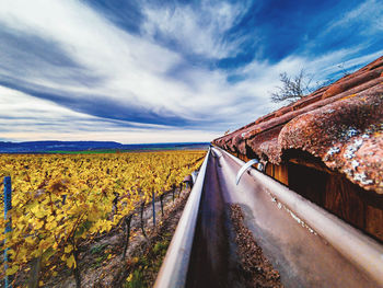 Road amidst field against sky