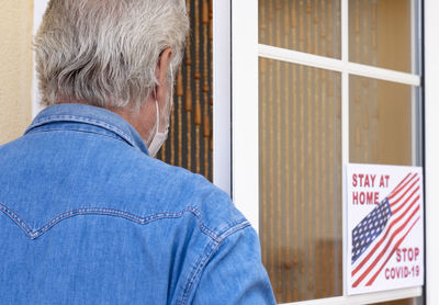 Rear view of man with text on window